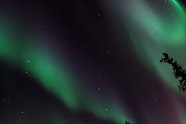 Paseo en moto de nieve bajo la aurora boreal